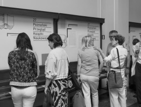Uczestnicy XXVII Poznańskiego Przeglądu Książki Naukowej przed gablotą z książkami